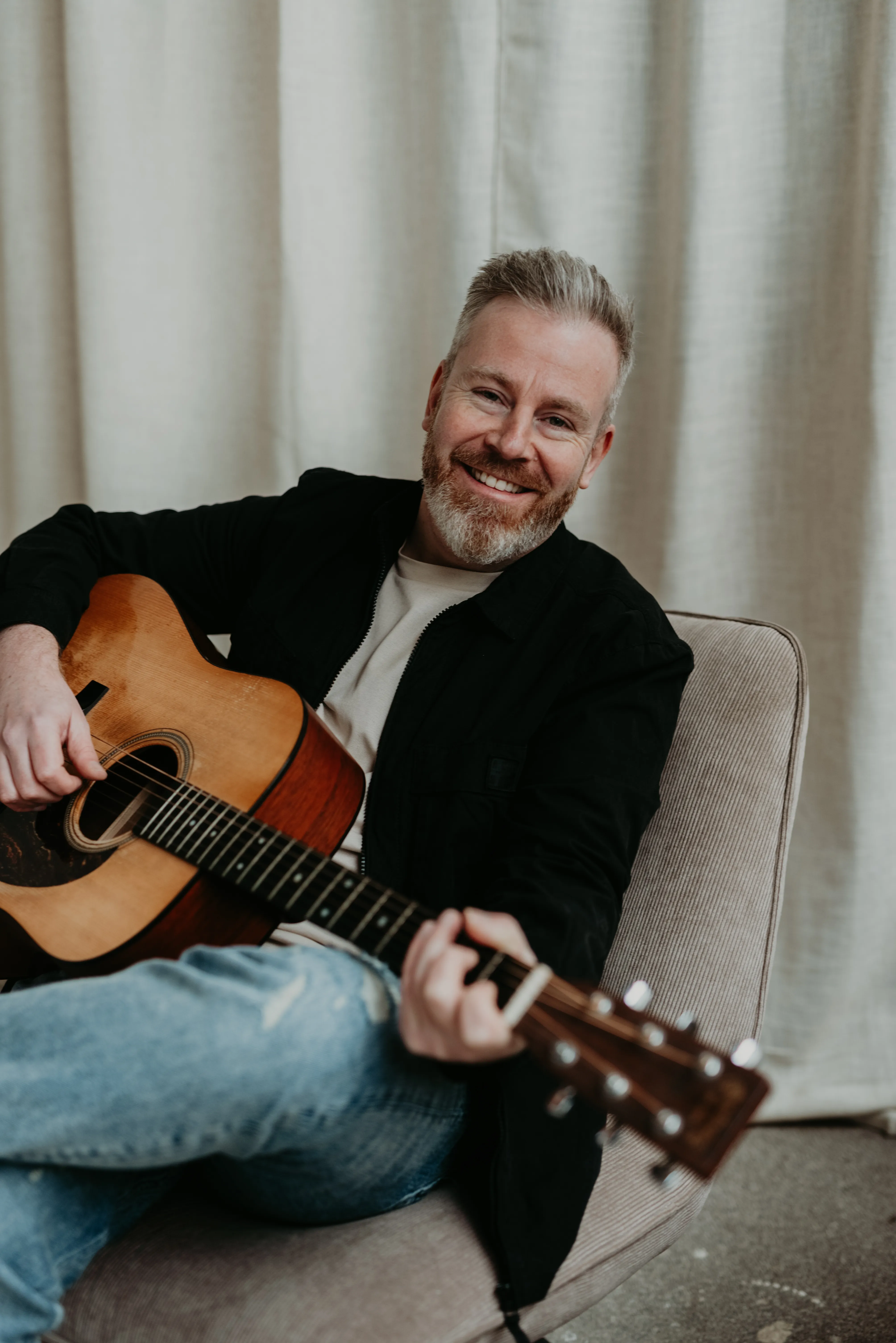 Ed Struijlaart lachend met gitaar