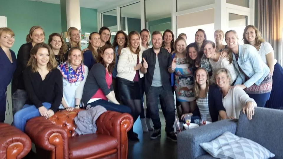 Groepsfoto na een huiskamerconcert — gezellige groep in de huiskamer