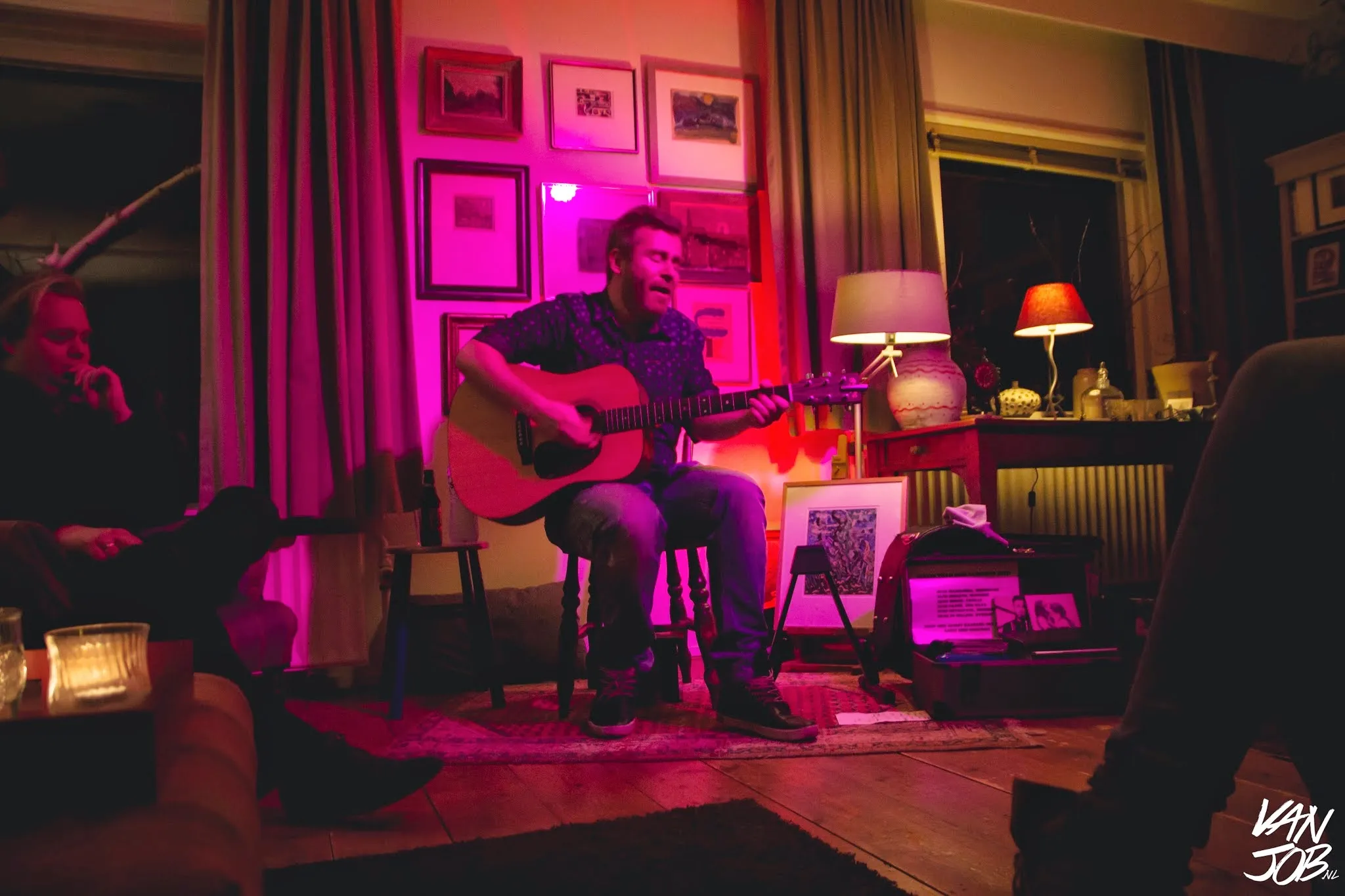 Ed Struijlaart speelt gitaar in een sfeervol verlichte huiskamer